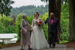 The bride walking up with her parents.