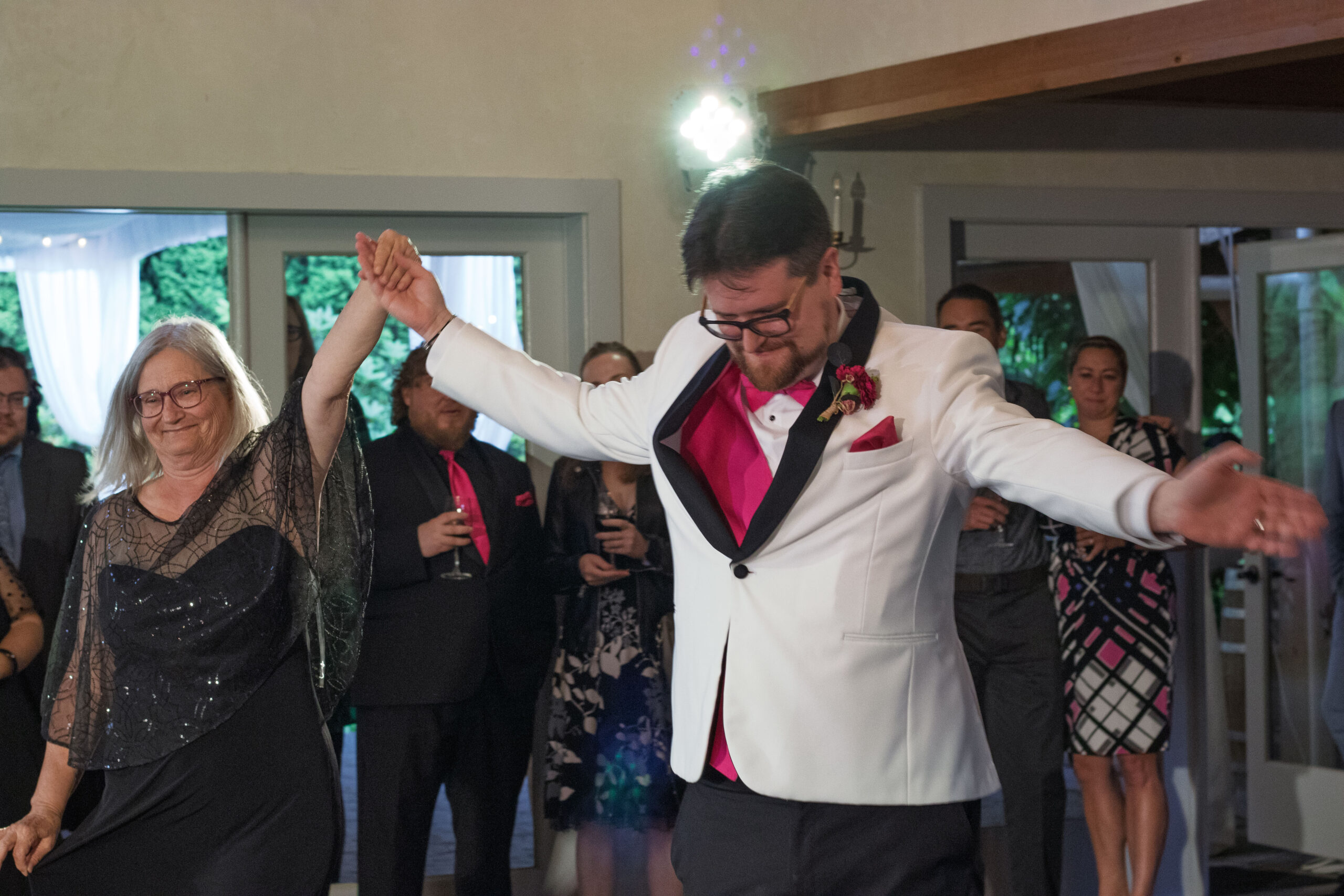 The groom bringing his mother out to the dance floor for their dance.