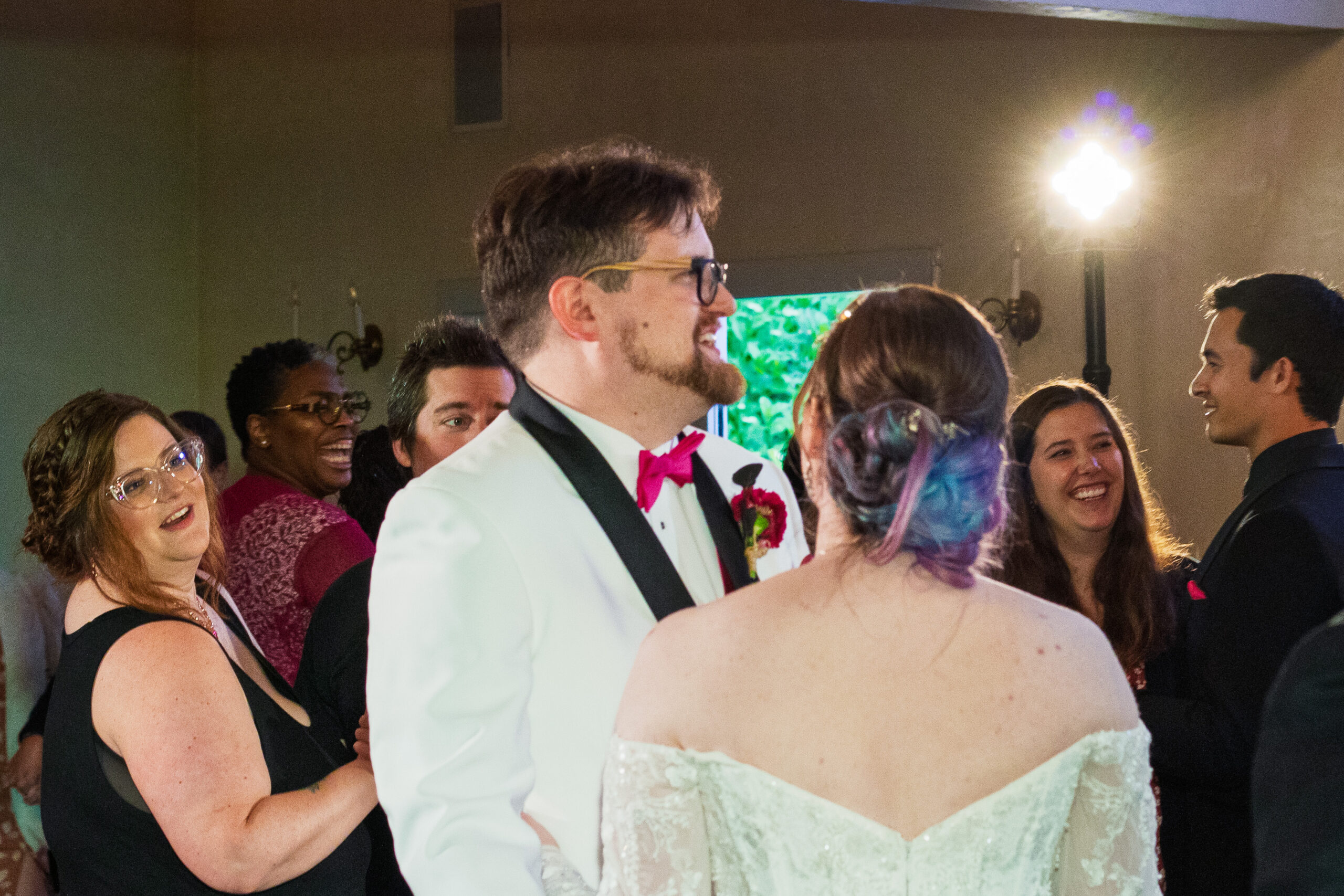 A candid shot of the bride and groom on the dance floor between dances and talking with friends.